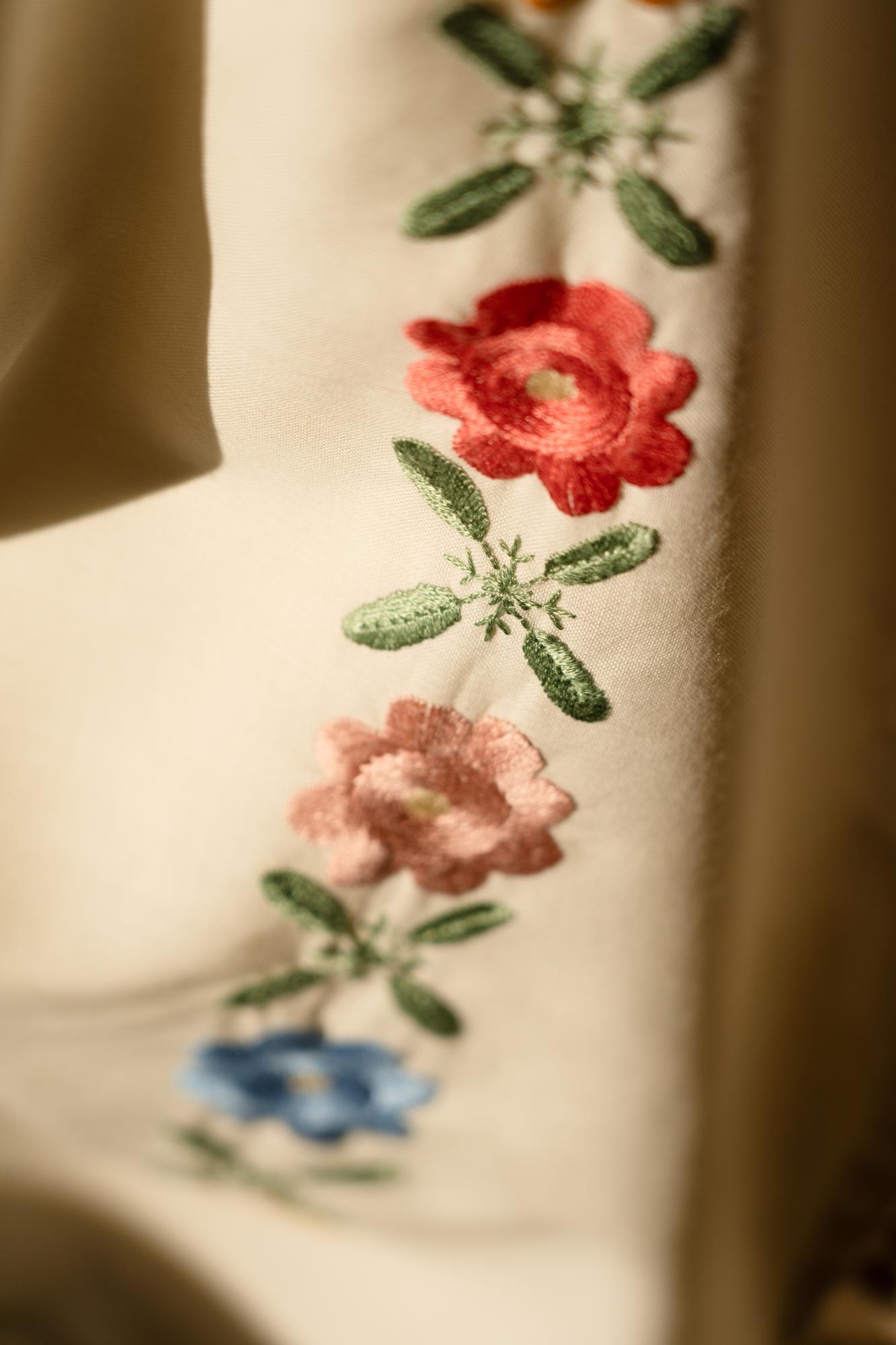 Close-up of embroidered floral threadwork on linen